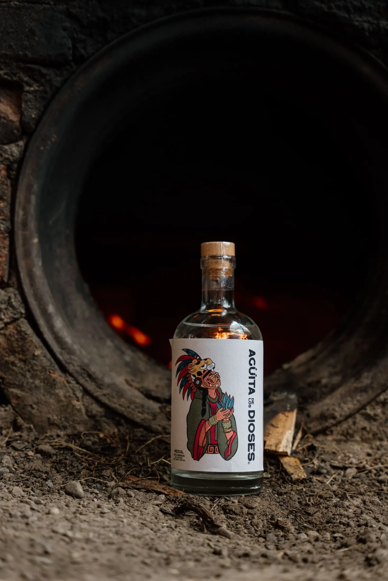 Bottle of mezcal lit by the oven's fire